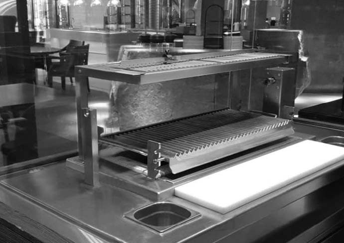 Stainless steel char grill with an adjustable grate in a professional kitchen